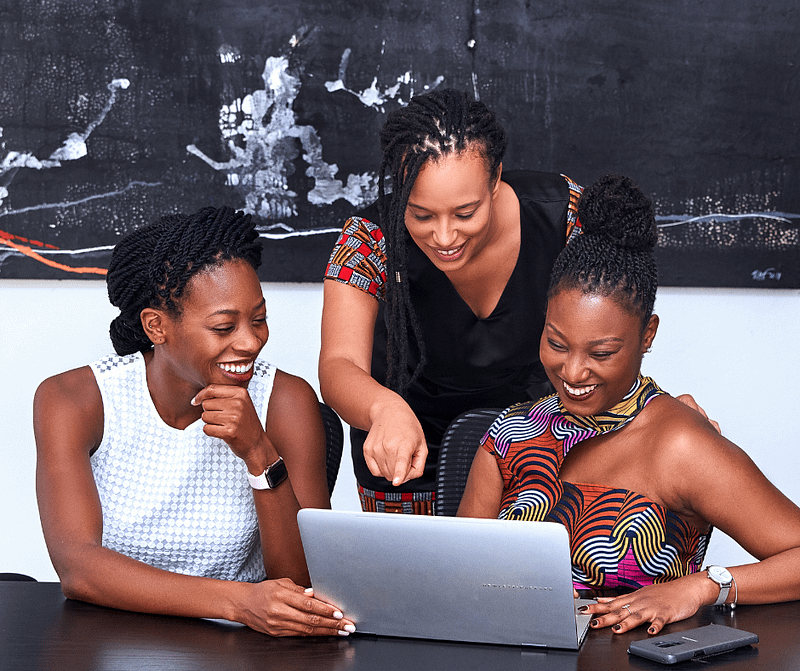 3 ladies looking at laptop happy