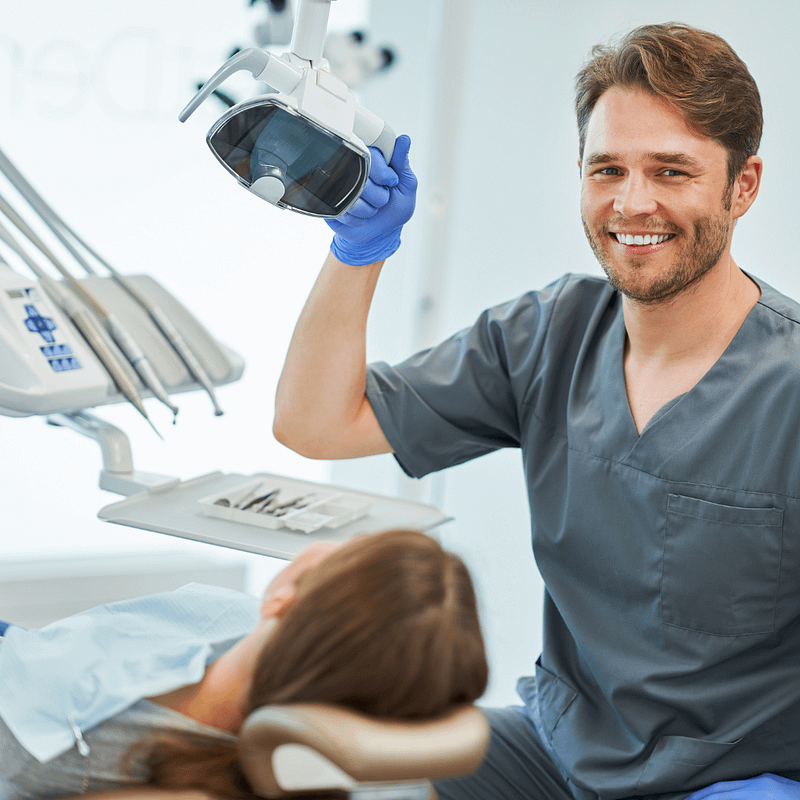 dentist sitting with a patient smiling